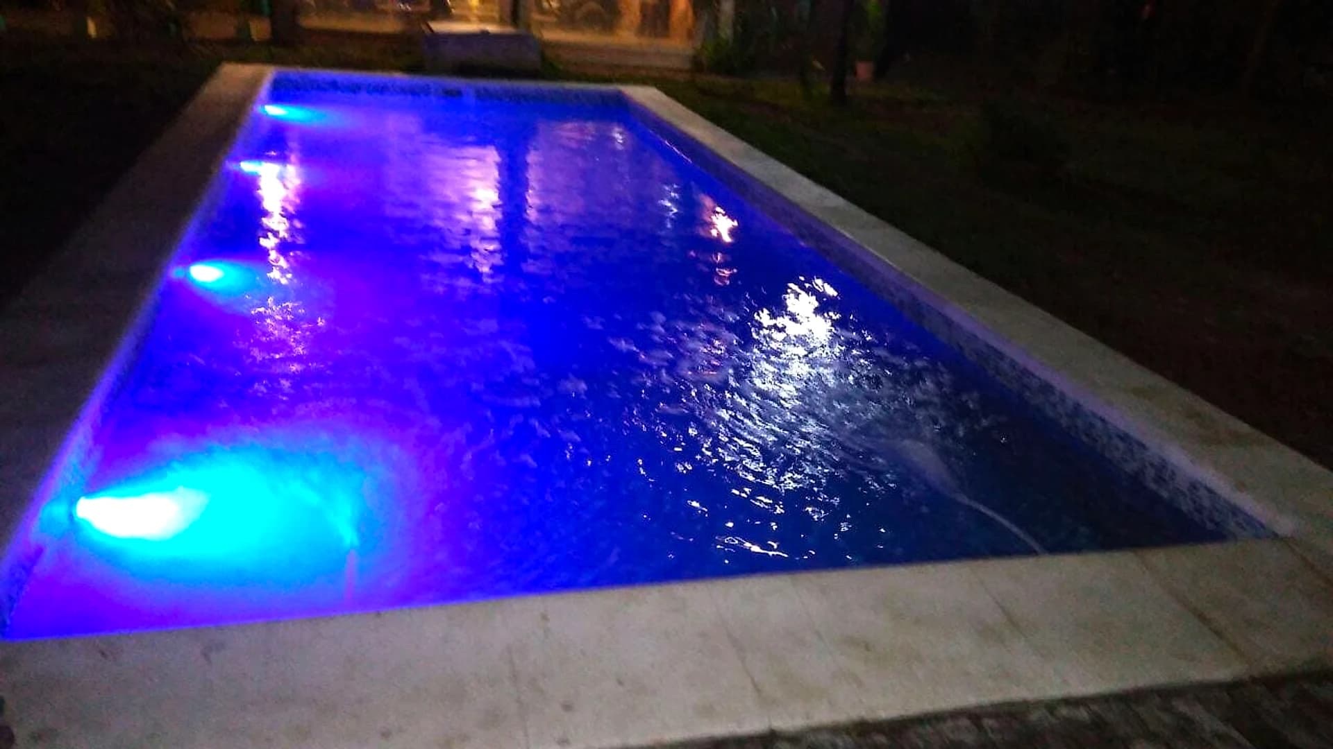 Piscina de noche iluminada con luces LED subacuáticas