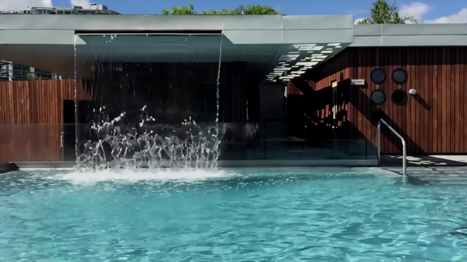 Piscina moderna con cascada de lámina de agua